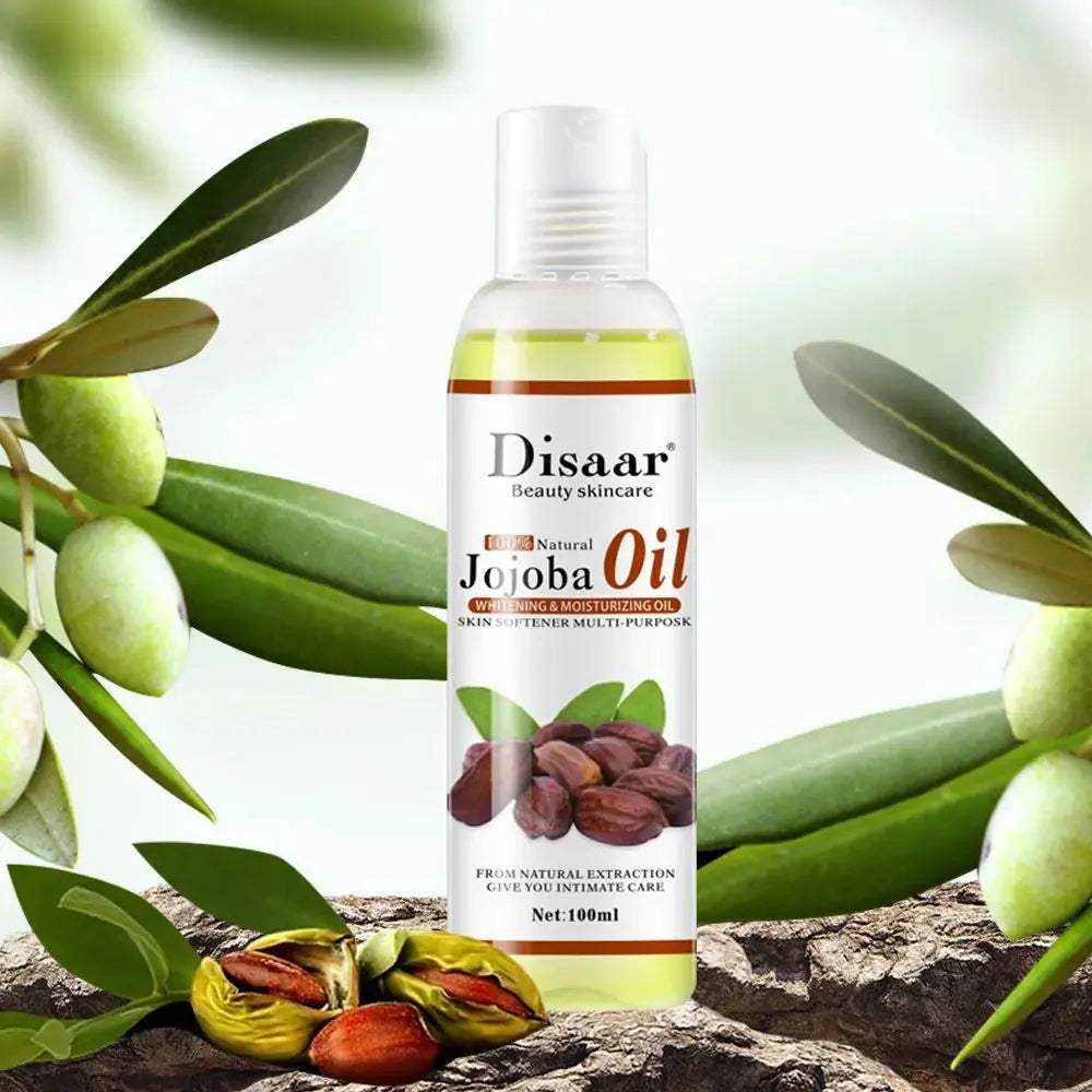 Un flacon dHuile essentielle de Jojoba Laikou de Jay Cosmetic, célèbre pour ses propriétés hydratantes, repose sur un fond de feuilles vertes et de graines brunes. La partie transparente du flacon blanc révèle lhuile à lintérieur et met en valeur ses bienfaits pour la peau.