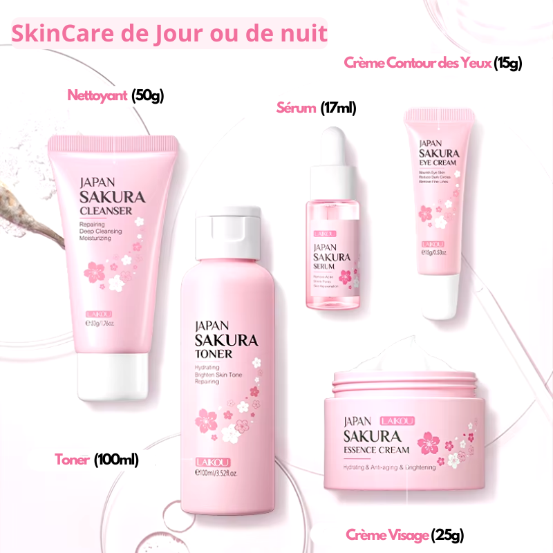 Lensemble de soins du visage Laikou Sakura de Jay Cosmetic est présenté sur une surface rose avec son Nettoyant Visage Sakura, son toner, sa crème, son sérum à la niacinamide et son baume à lèvres dans un emballage sur le thème des fleurs de cerisier. Une boîte ouverte révélant un motif floral se trouve au milieu de pétales de fleurs de cerisier dispersés.